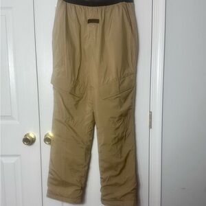 fear of god essentials storm pant in the 'oak' or tan color, made of polyester